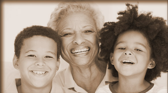 grandmother smiling and embracing grandson and granddaughter